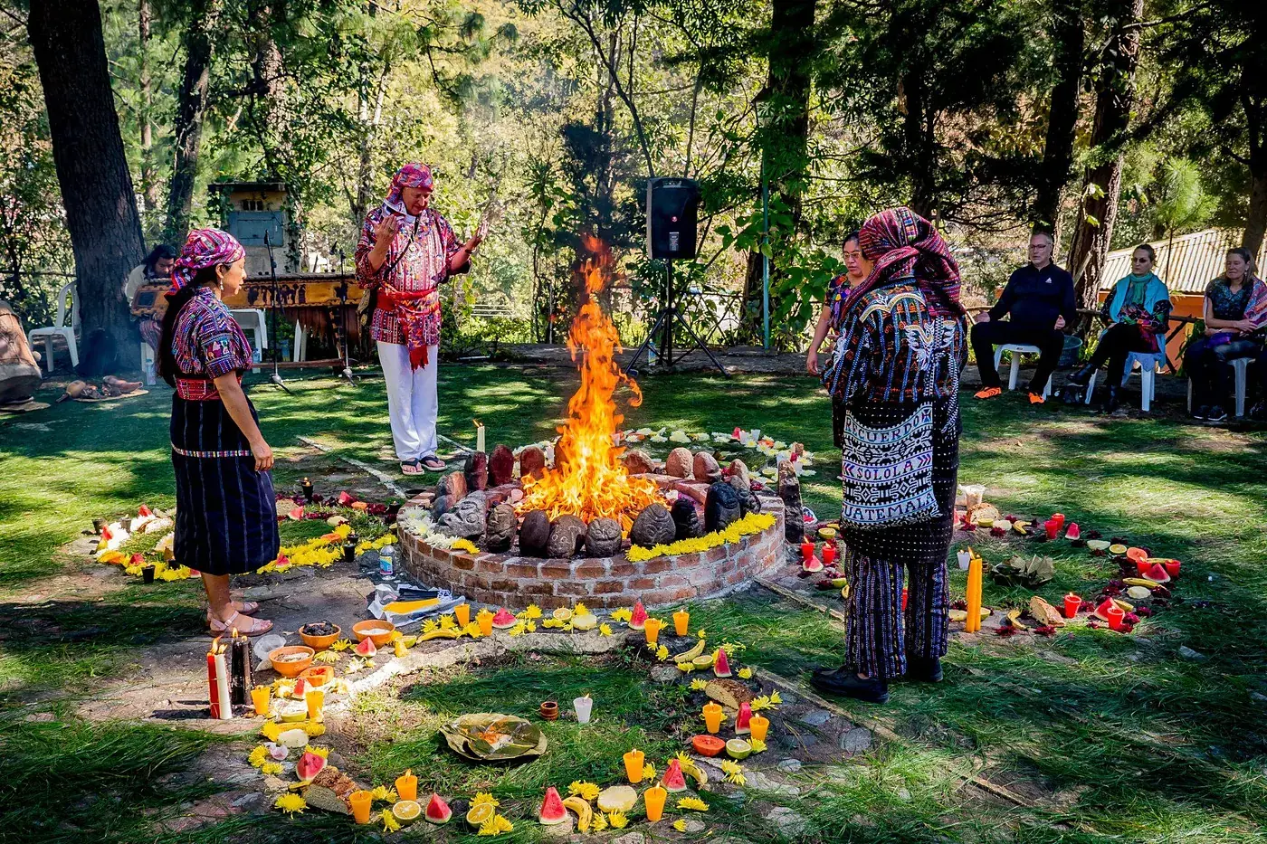 Eine Feuerzeremonie im Garten des Zentrums, Blumen im Kreis um das Feuer gelegt