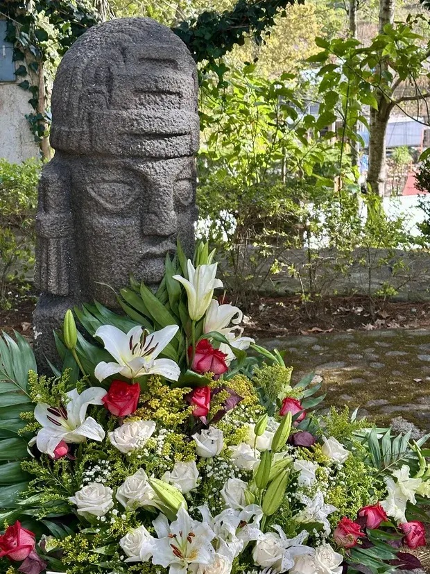 Eine Mayastele zwischen Bäumen im Garten des Zentrums