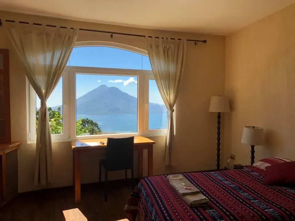 Ein Gästezimmer mit Schreibtisch am Fenster, Blick auf den See